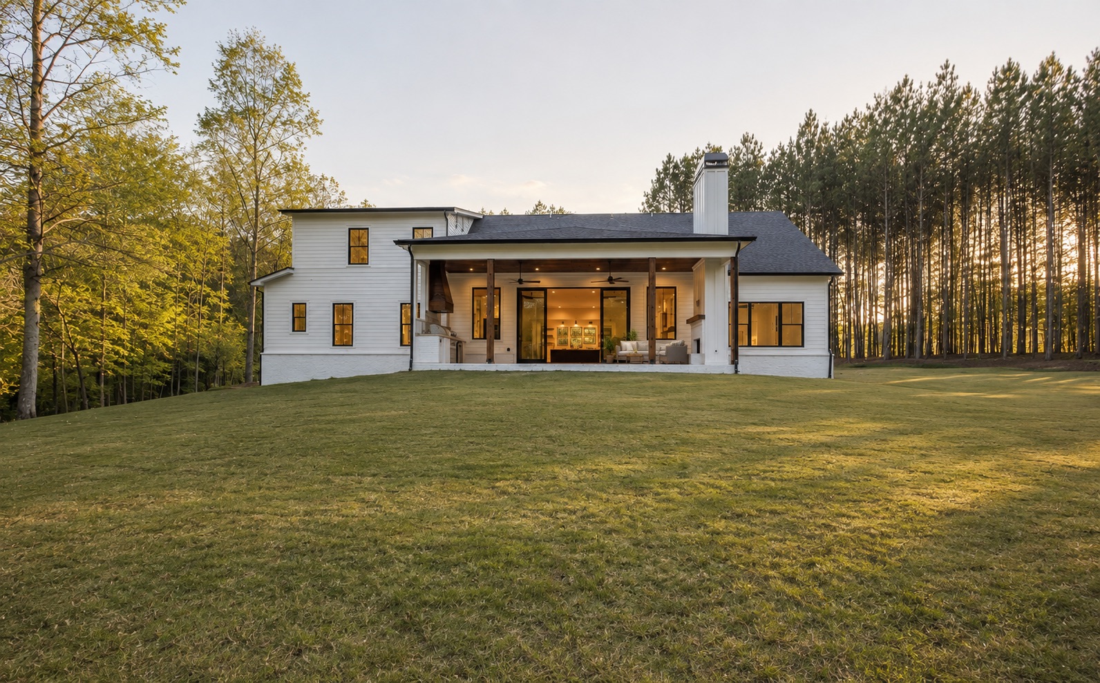 Rear exterior surrounded by private lawn and woods